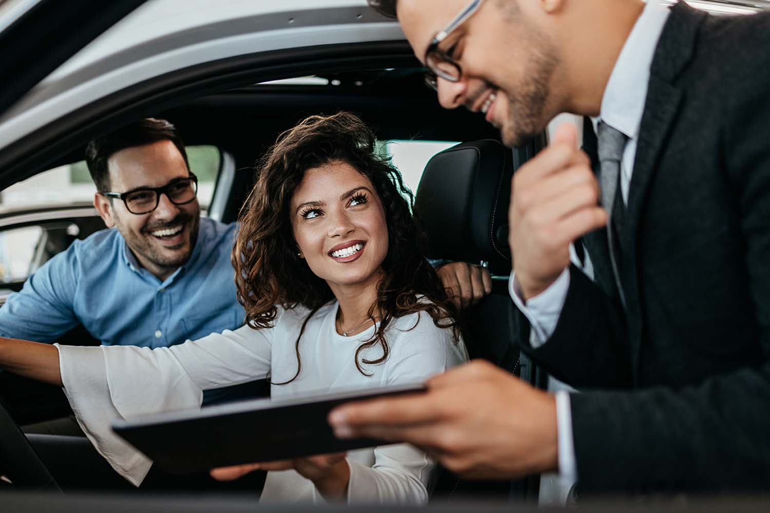 Asesor brindando información a clientes interesados en la compra de un carro