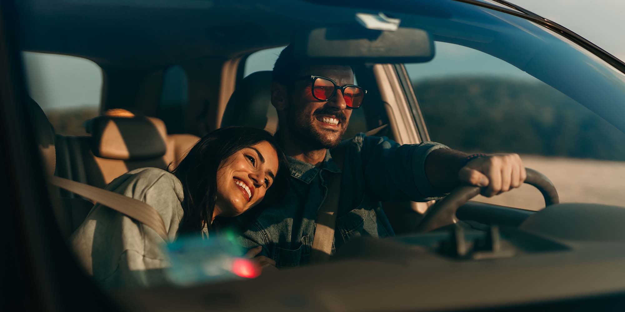 Pareja disfrutando un viaje en auto al atardecer